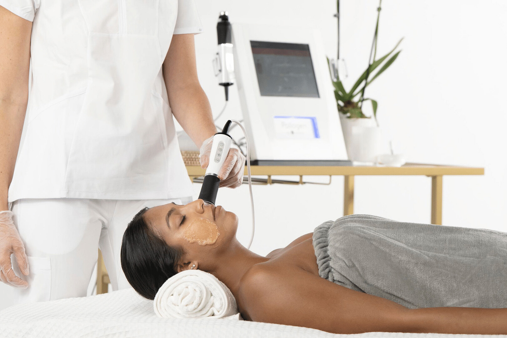 Woman receiving skin exfoliation with a Geneo facial treatment at a spa