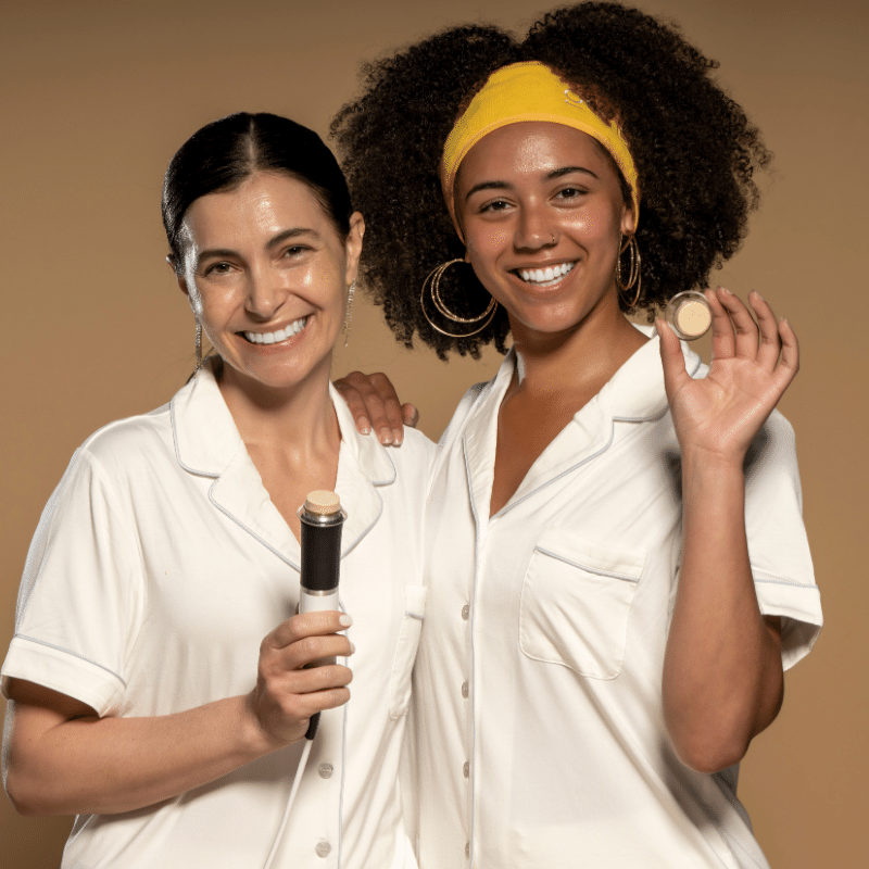 Two women smiling and holding Geneo facial treatment wand and oxypods