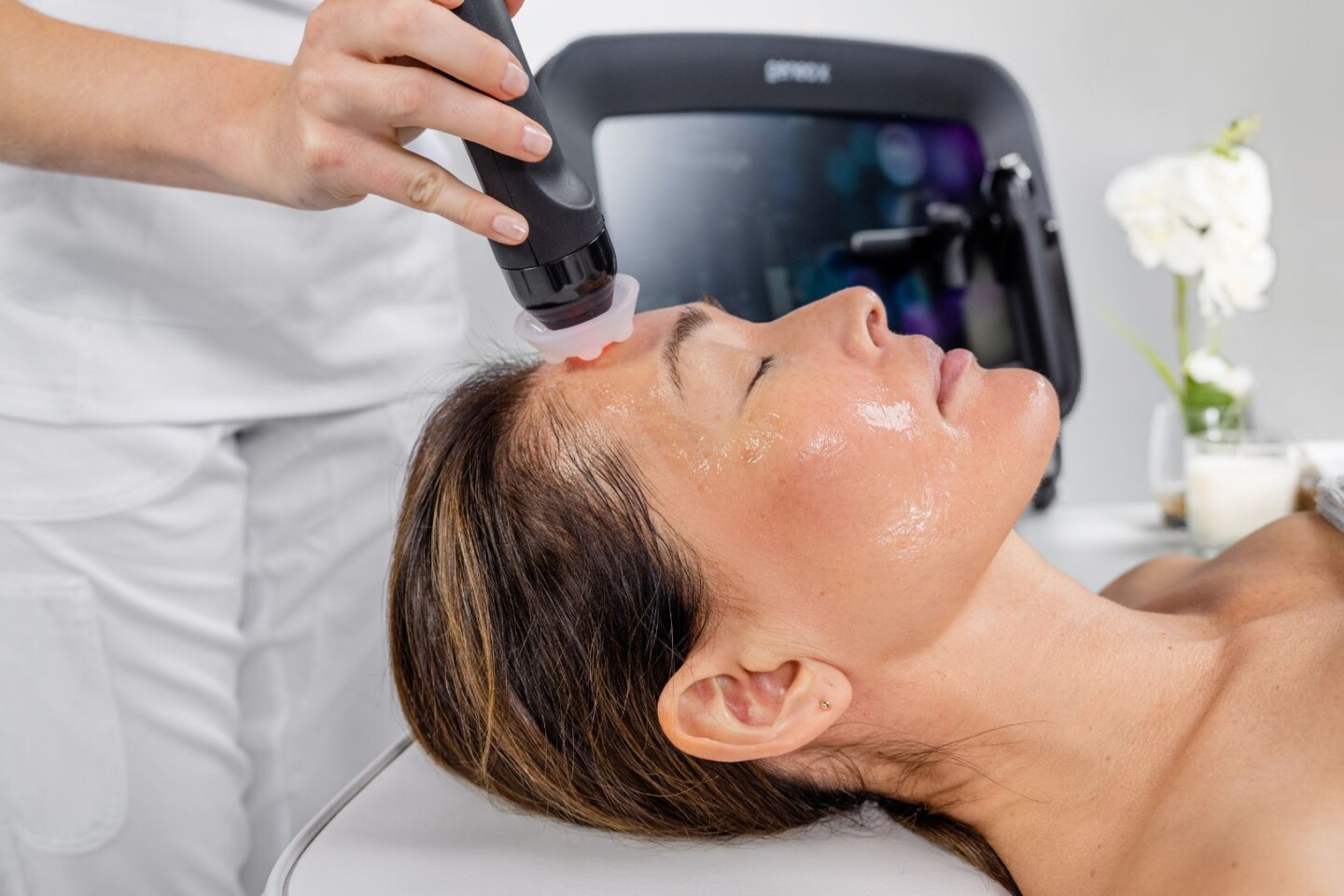 Woman receiving Geneo facial treatment for textured skin, uneven skin tone